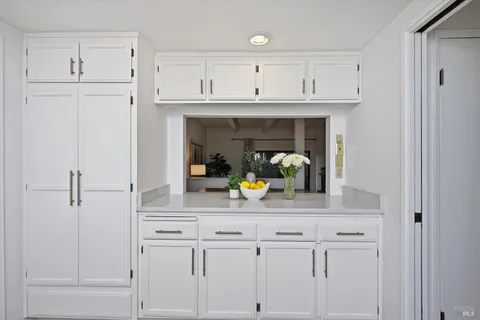 a view of a kitchen with white cabinets