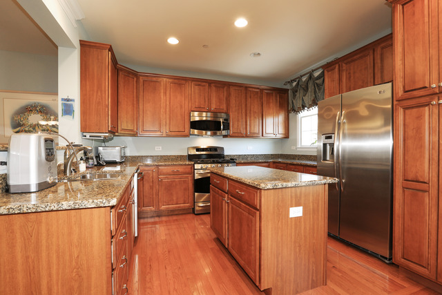 2808 Commons Drive Glenview, IL 60026 - Photo 5 of 14 a kitchen with stainless steel appliances granite countertop a stove a sink dishwasher a refrigerator and a microwave oven with wooden floor