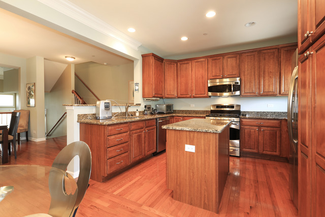 2808 Commons Drive Glenview, IL 60026 - Photo 6 of 14 a kitchen with stainless steel appliances granite countertop wooden cabinets a stove a sink and a wooden floors