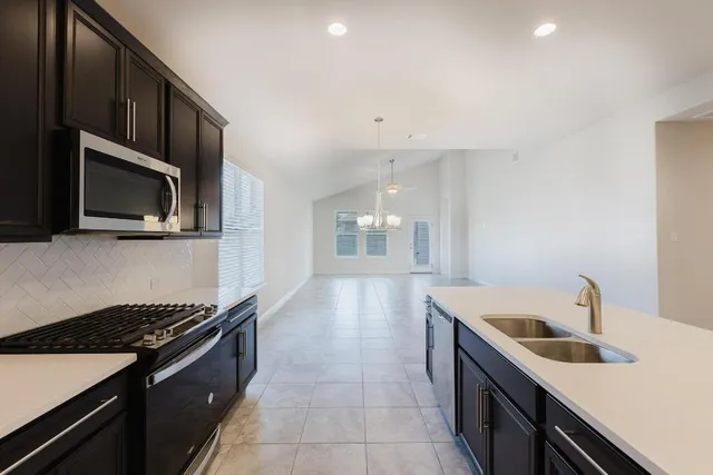 a kitchen that has a sink and a stove top oven