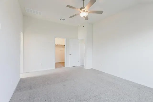 an empty room with a ceiling fan and a window