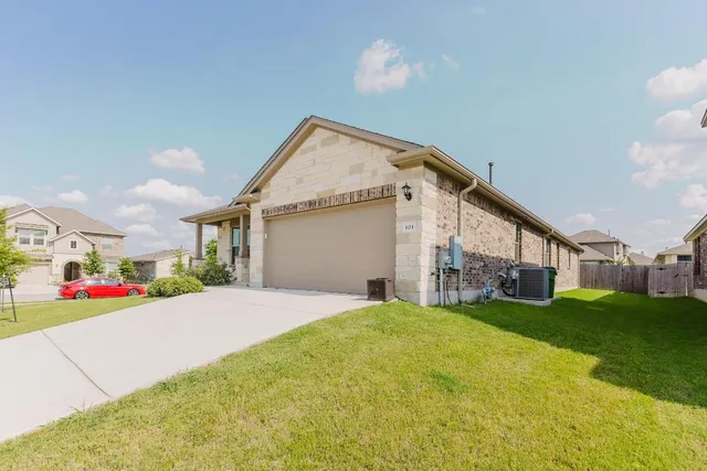 a view of a house with a yard and garage