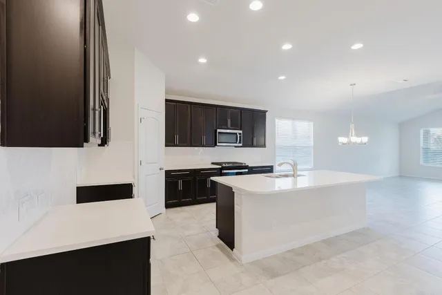 a large white kitchen with stainless steel appliances