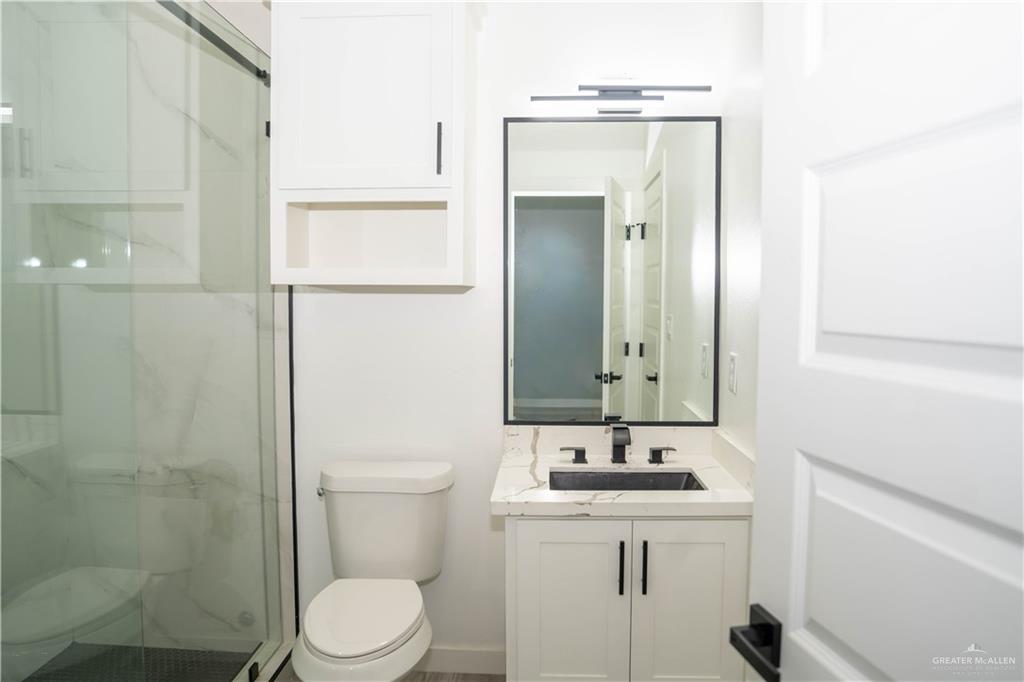 106 West Eldora Road San Juan, TX 78589 - Photo 18 of 29 a bathroom with a toilet a sink a mirror and vanity