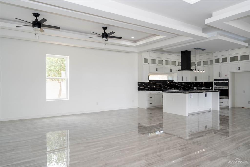 106 West Eldora Road San Juan, TX 78589 - Photo 6 of 29 a kitchen with granite countertop a stove cabinets and a wooden floor