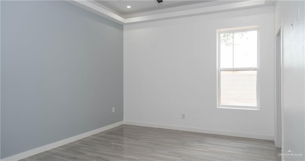 106 West Eldora Road San Juan, TX 78589 - Photo 7 of 29 an empty room with wooden floor and windows