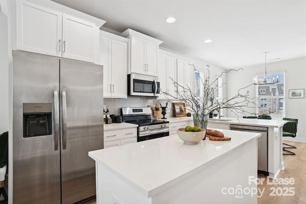 6134 Wilora Lake Road Charlotte, NC 28212 - Photo 6 of 21 a kitchen with a sink a counter top space stainless steel appliances and cabinets