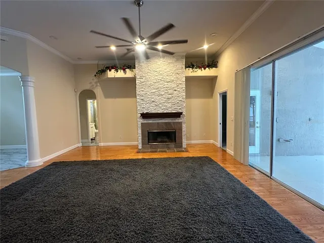 an empty room with wooden floor mirror and windows