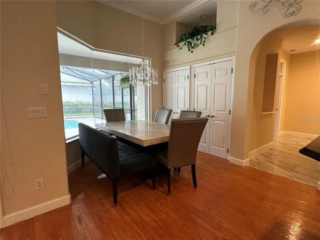 a kitchen with granite countertop a refrigerator a sink a stove a microwave a dining table and chairs