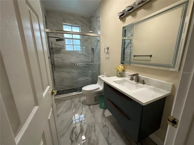 an empty room with wooden floor windows and chandelier