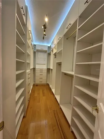 a view of an empty room with a fireplace and a chandelier fan