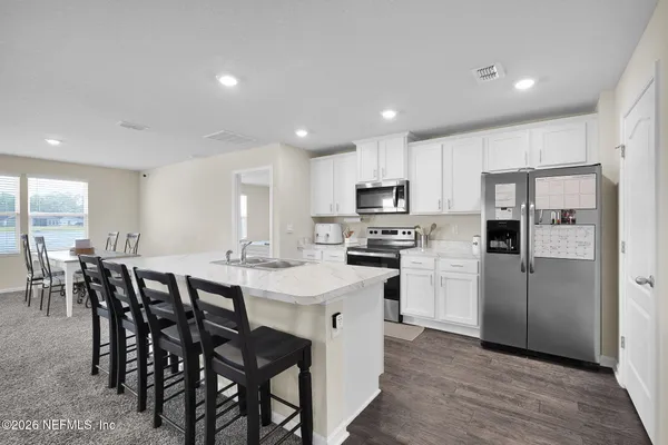a kitchen with refrigerator and chairs