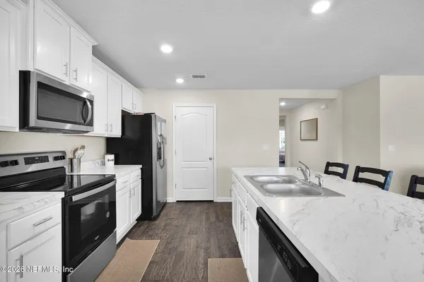 a kitchen with a sink a stove top oven and refrigerator
