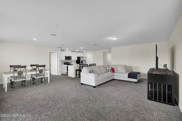 a living room with furniture and kitchen view