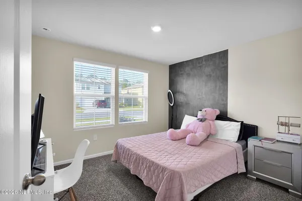 a bedroom with a bed and a flat tv screen
