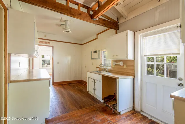 a view of a kitchen with a sink and wooden floor