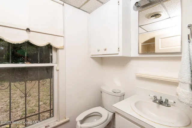 a bathroom with a sink a toilet and a mirror