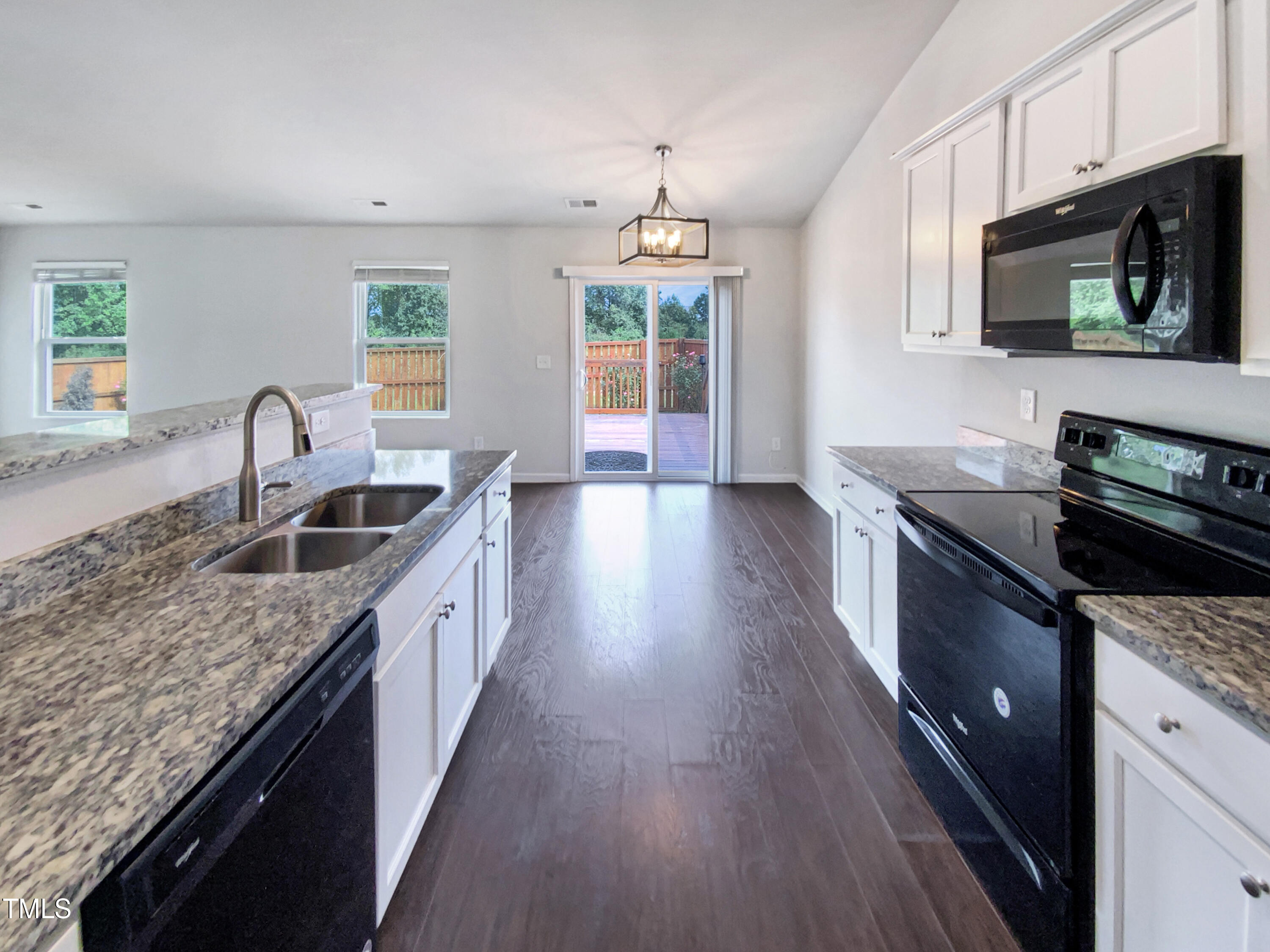 337 Rustling Way Zebulon, NC 27597 - Photo 6 of 19 a kitchen with granite countertop a sink wooden floor and stainless steel appliances