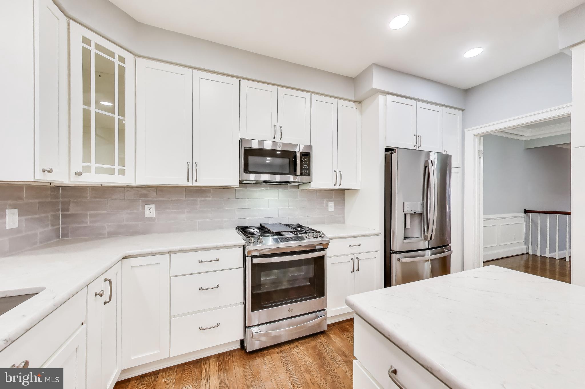 8017 Rising Ridge Road Bethesda, MD 20817 - Photo 12 of 54 a kitchen with white cabinets and stainless steel appliances