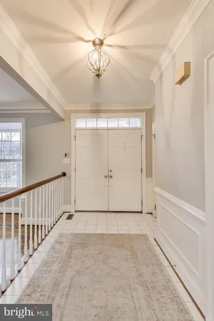 a view of an empty room with chandelier fan