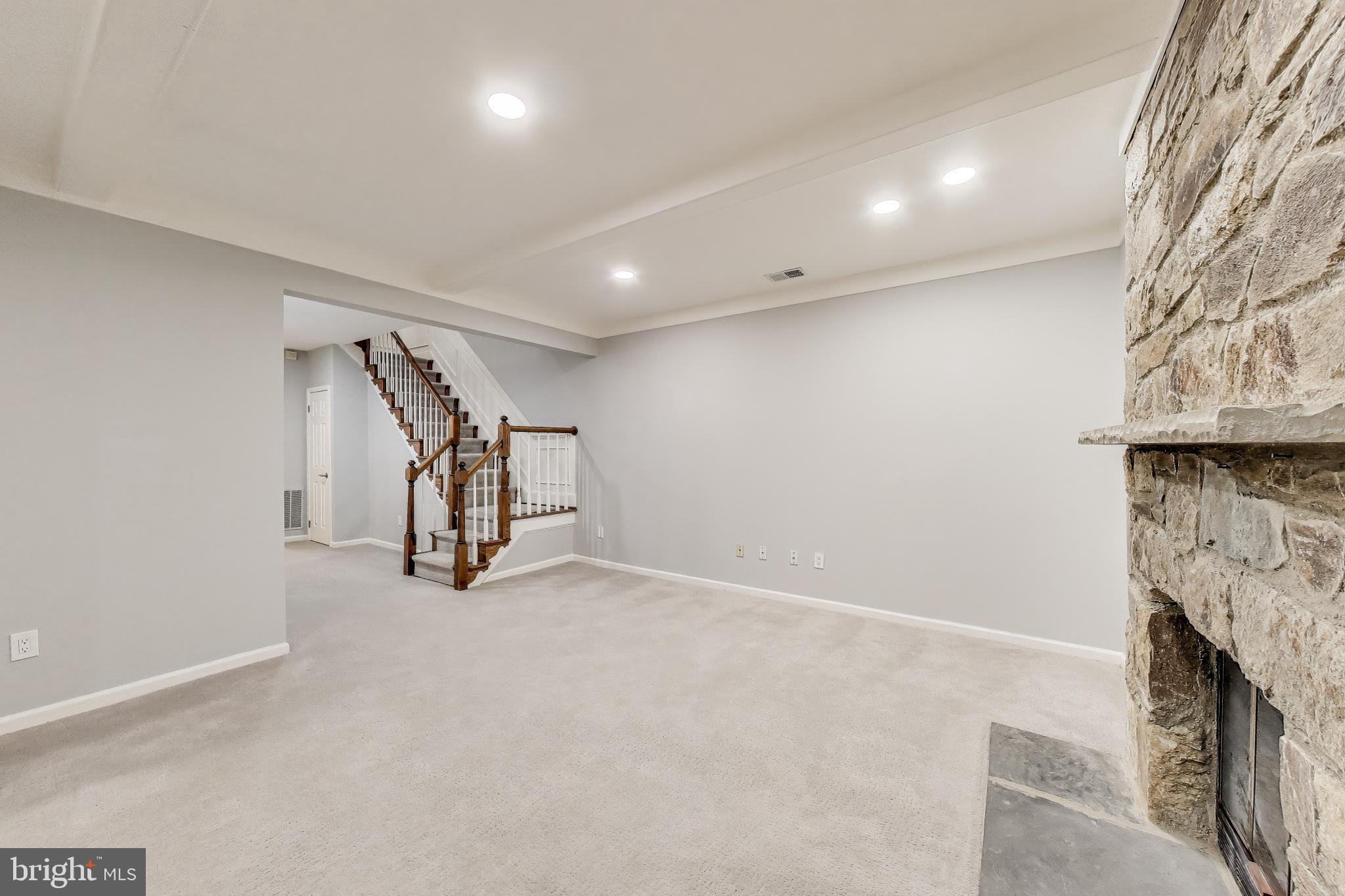 8017 Rising Ridge Road Bethesda, MD 20817 - Photo 35 of 54 an empty room with stairs and a fireplace
