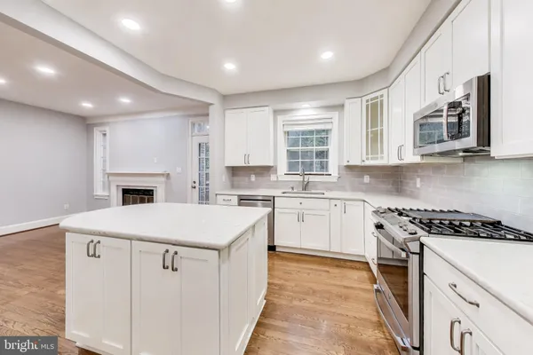 a kitchen with a stove a sink and a microwave