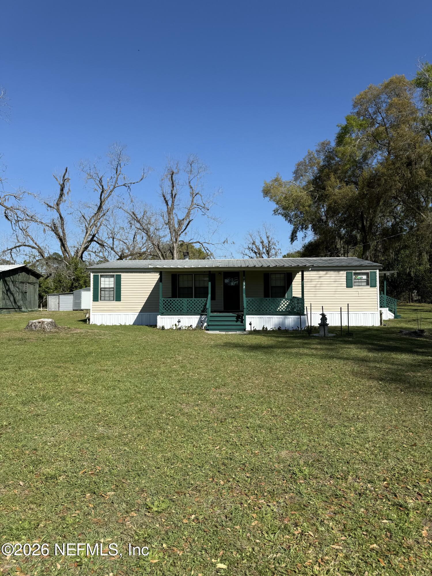 a front view of a house with a garden and yard