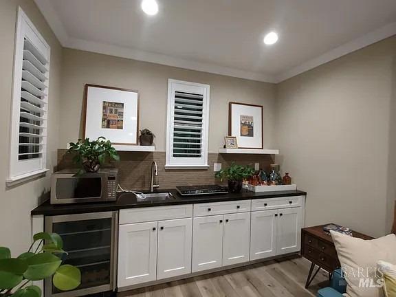 a kitchen with cabinets a potted plant on the counter and a wooden floors