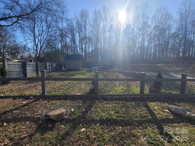 a view of a yard with wooden fence