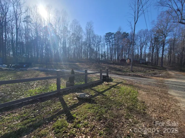 a view of a yard with wooden fence