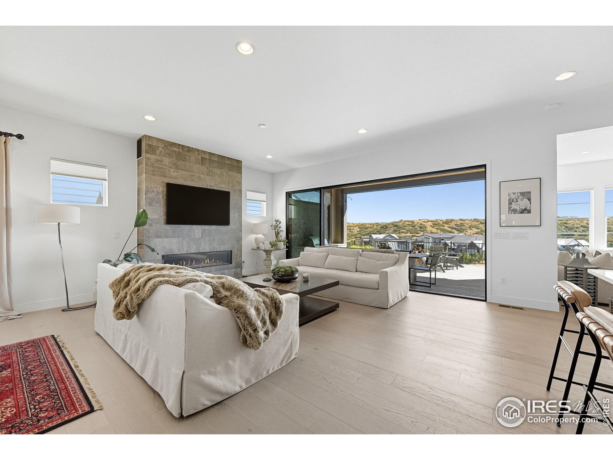 7382 Canyonpoint Road Castle Pines, CO 80108 - Photo 12 of 49 a living room with furniture and a flat screen tv