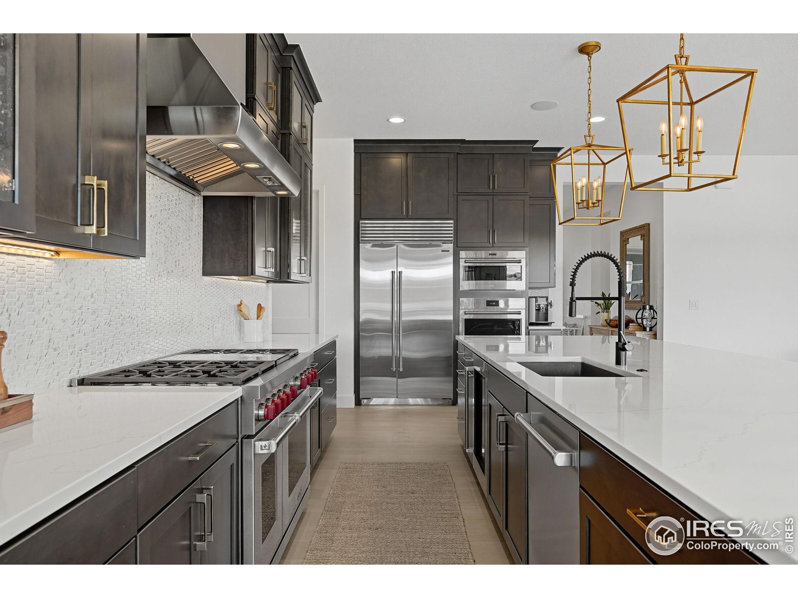 7382 Canyonpoint Road Castle Pines, CO 80108 - Photo 20 of 49 a kitchen with stainless steel appliances granite countertop a sink stove and refrigerator