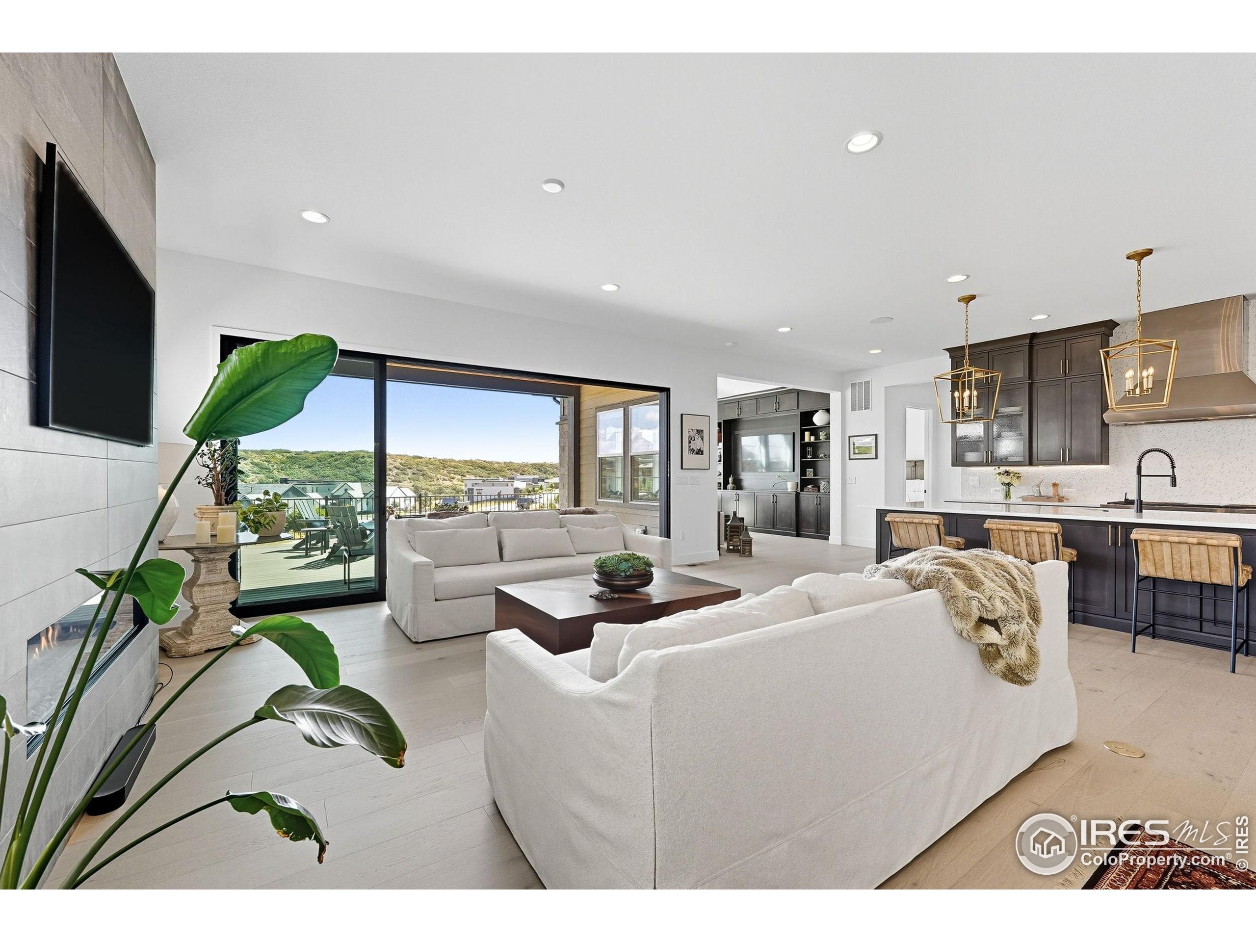 7382 Canyonpoint Road Castle Pines, CO 80108 - Photo 22 of 49 a living room with stainless steel appliances kitchen island furniture and a flat screen tv