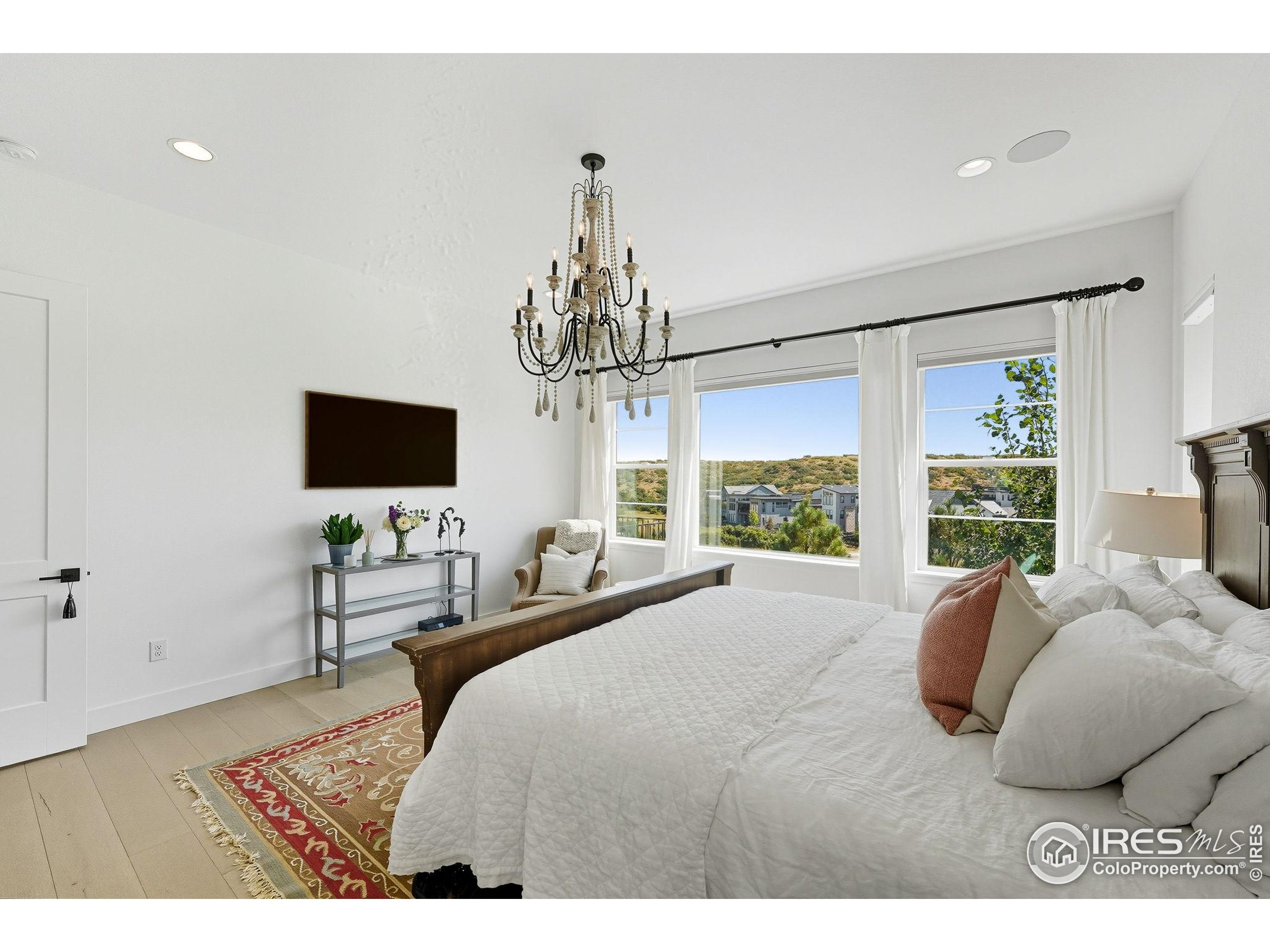 7382 Canyonpoint Road Castle Pines, CO 80108 - Photo 26 of 49 a bedroom with bed tv and window