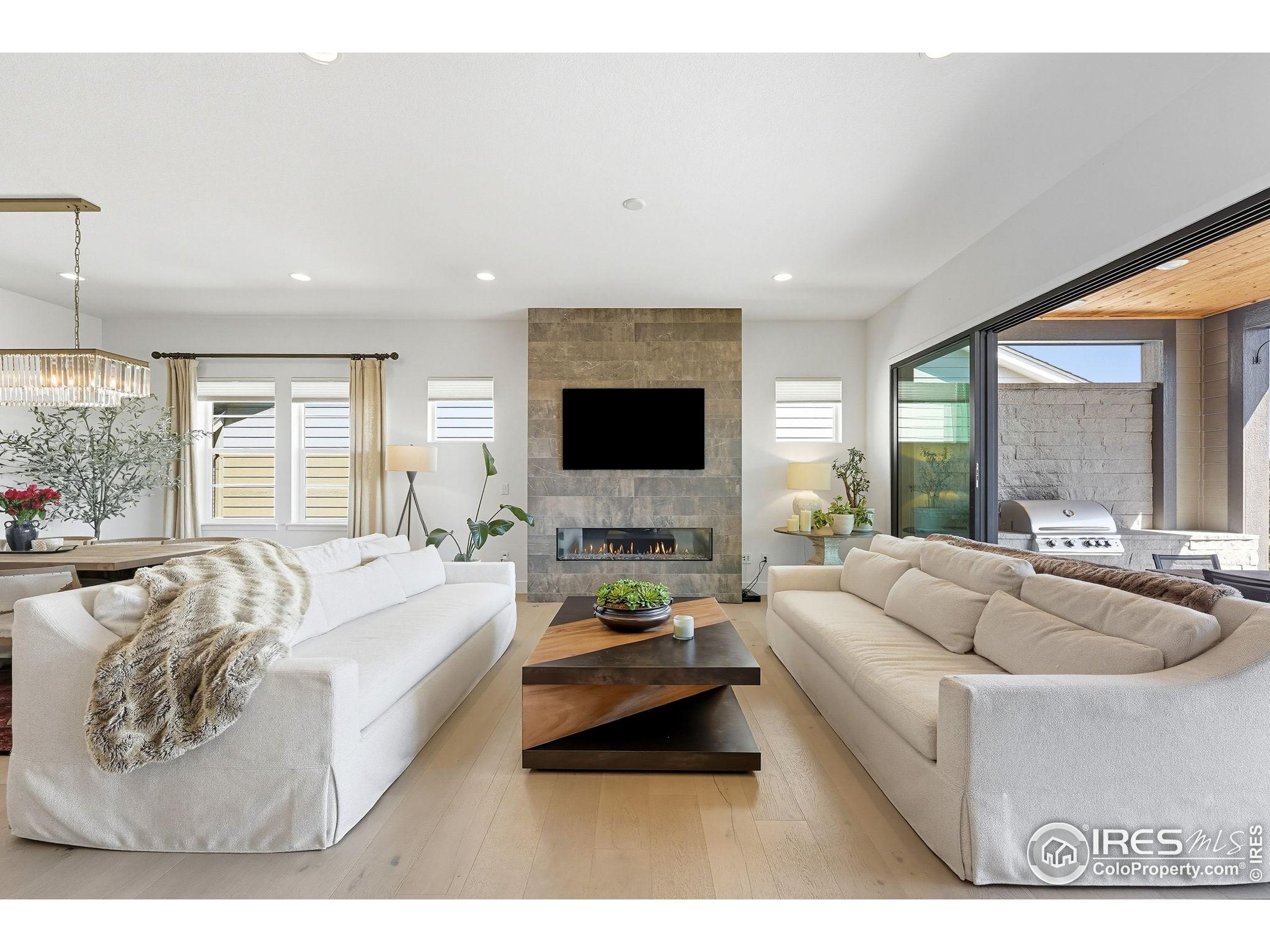 7382 Canyonpoint Road Castle Pines, CO 80108 - Photo 4 of 49 a living room with furniture flat screen tv and a large window