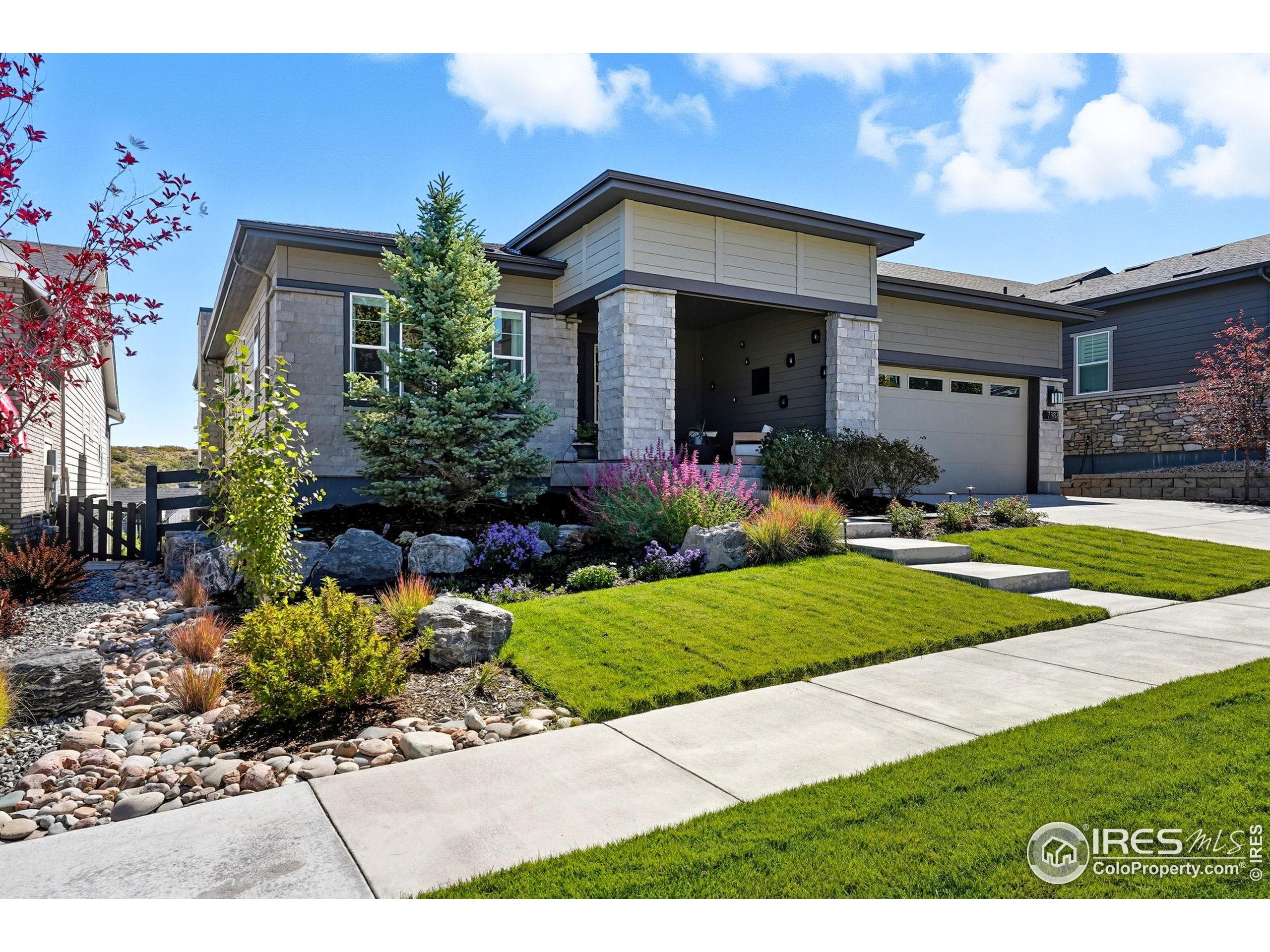 7382 Canyonpoint Road Castle Pines, CO 80108 - Photo 7 of 49 a front view of a house with a yard and potted plants