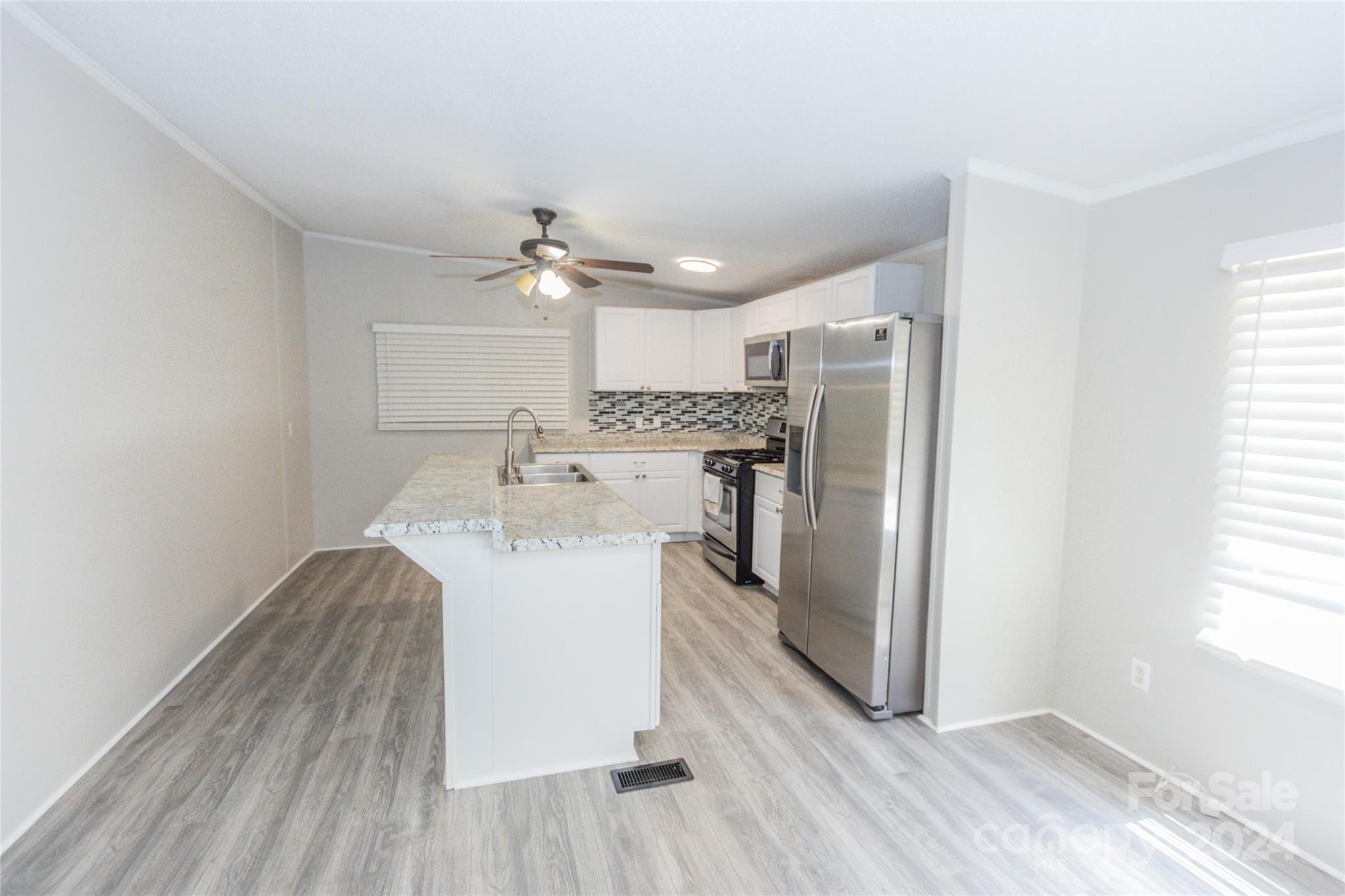 1994 Zion Road Lancaster, SC 29720 - Photo 19 of 45 a kitchen with kitchen island stainless steel appliances a sink cabinets and wooden floor