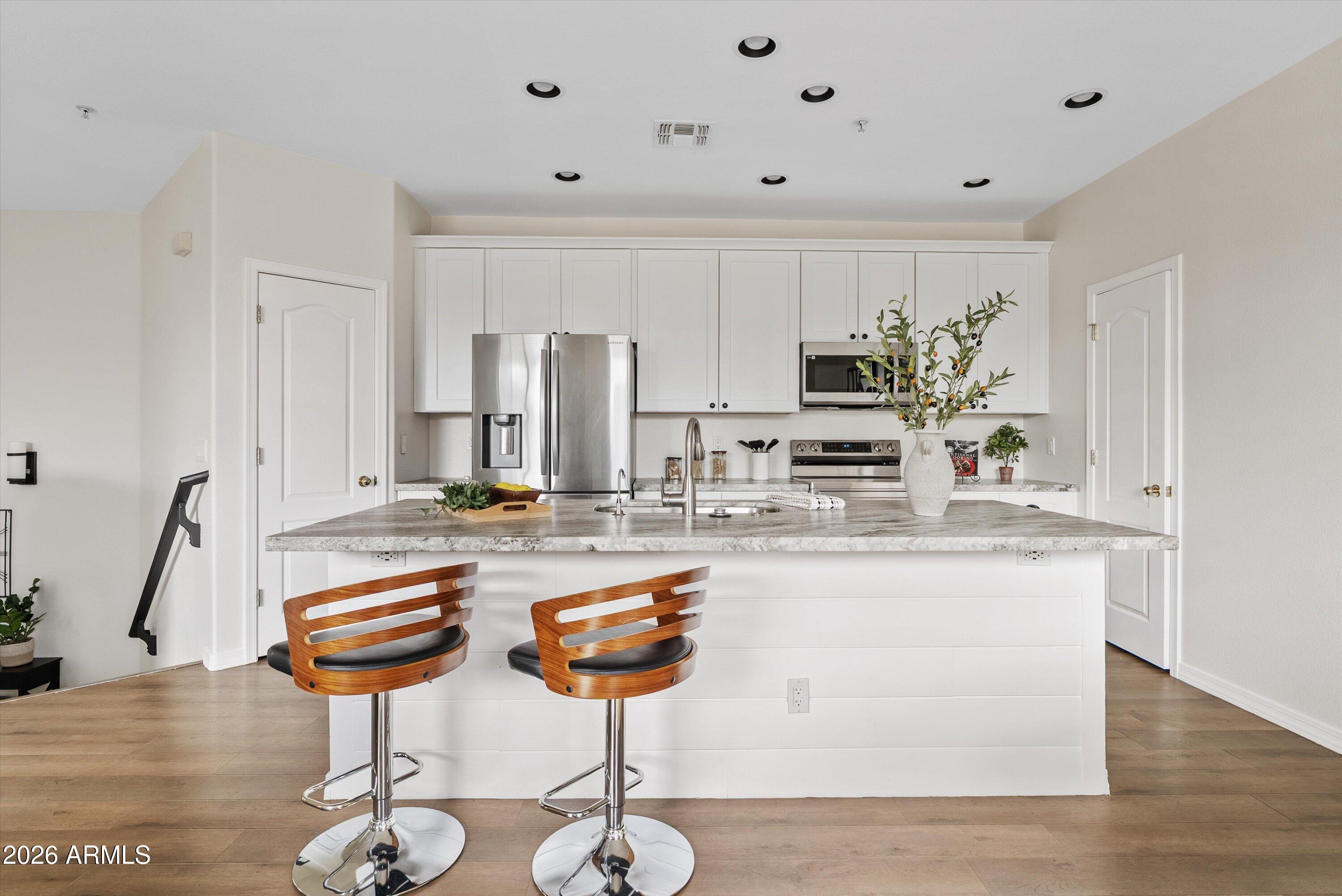 1265 South Aaron, Unit 245 Mesa, AZ 85209 - Photo 5 of 30 a kitchen with appliances cabinets and wooden floor