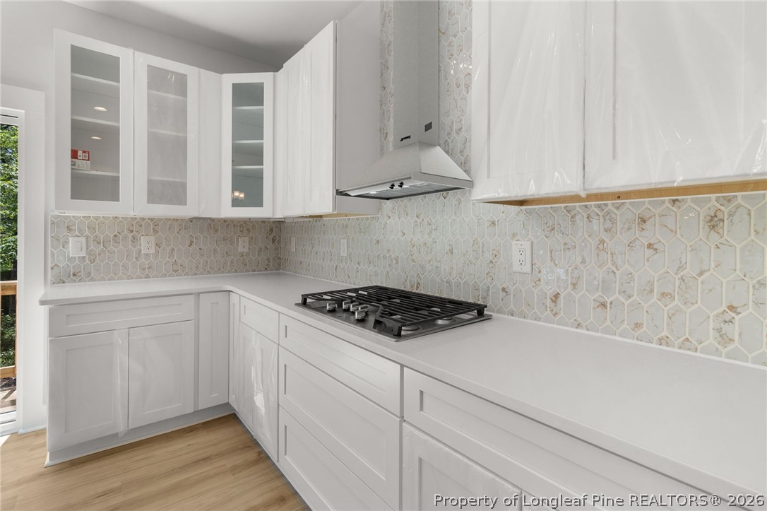 408 Stable Court Linden, NC 28356 - Photo 8 of 29 a kitchen with white cabinets and a stove with wooden floor