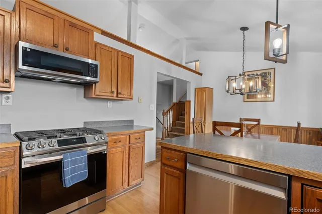 a kitchen with stainless steel appliances granite countertop a stove a sink and a microwave