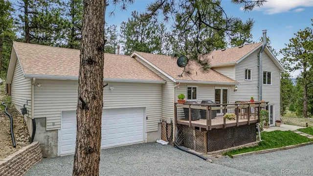 a view of house with a yard and large tree