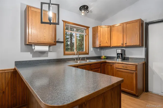 a kitchen with stainless steel appliances granite countertop a sink a window and a kitchen island