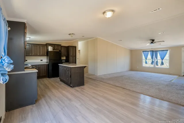 a large kitchen with a wooden floor and stainless steel appliances