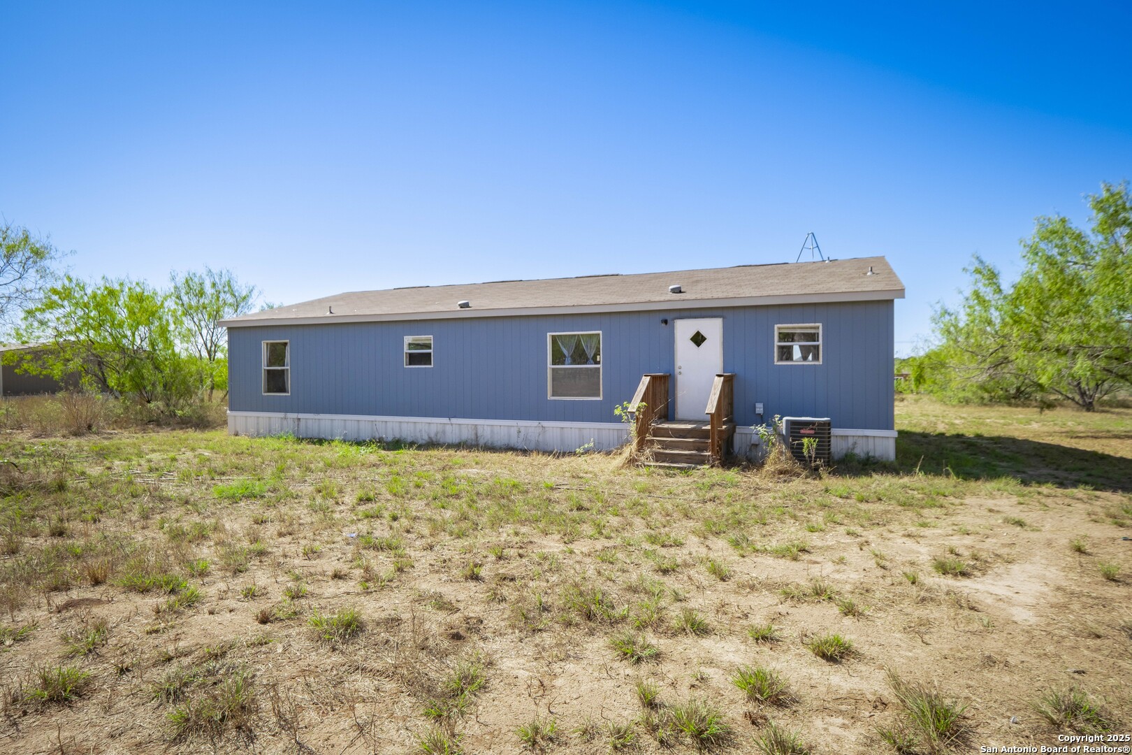 1007 County Road 773 Devine, TX 78016 - Photo 29 of 31 a backyard of a house with table and chairs