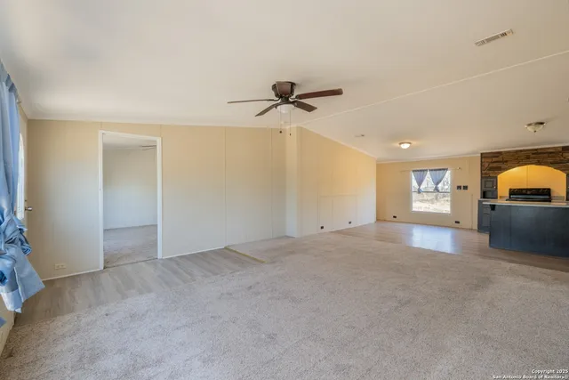 a view of a livingroom with a ceiling fan and window