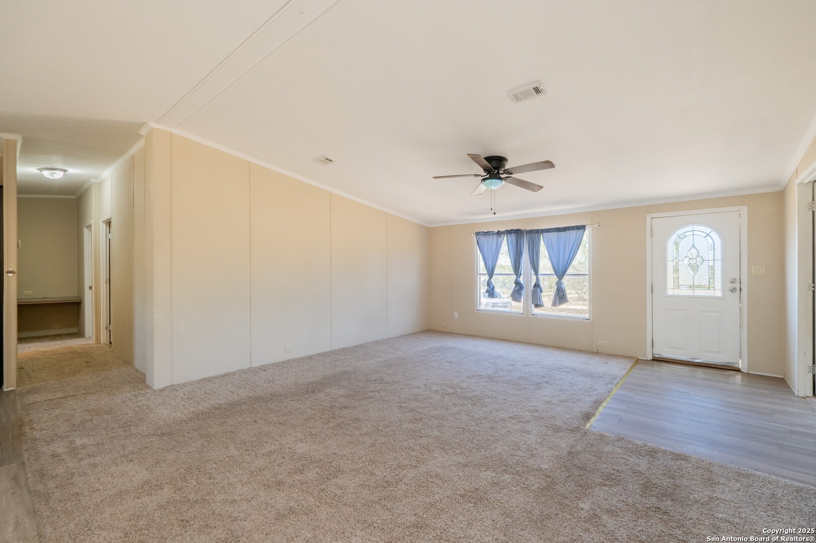 1007 County Road 773 Devine, TX 78016 - Photo 7 of 31 an empty room with windows and ceiling fan