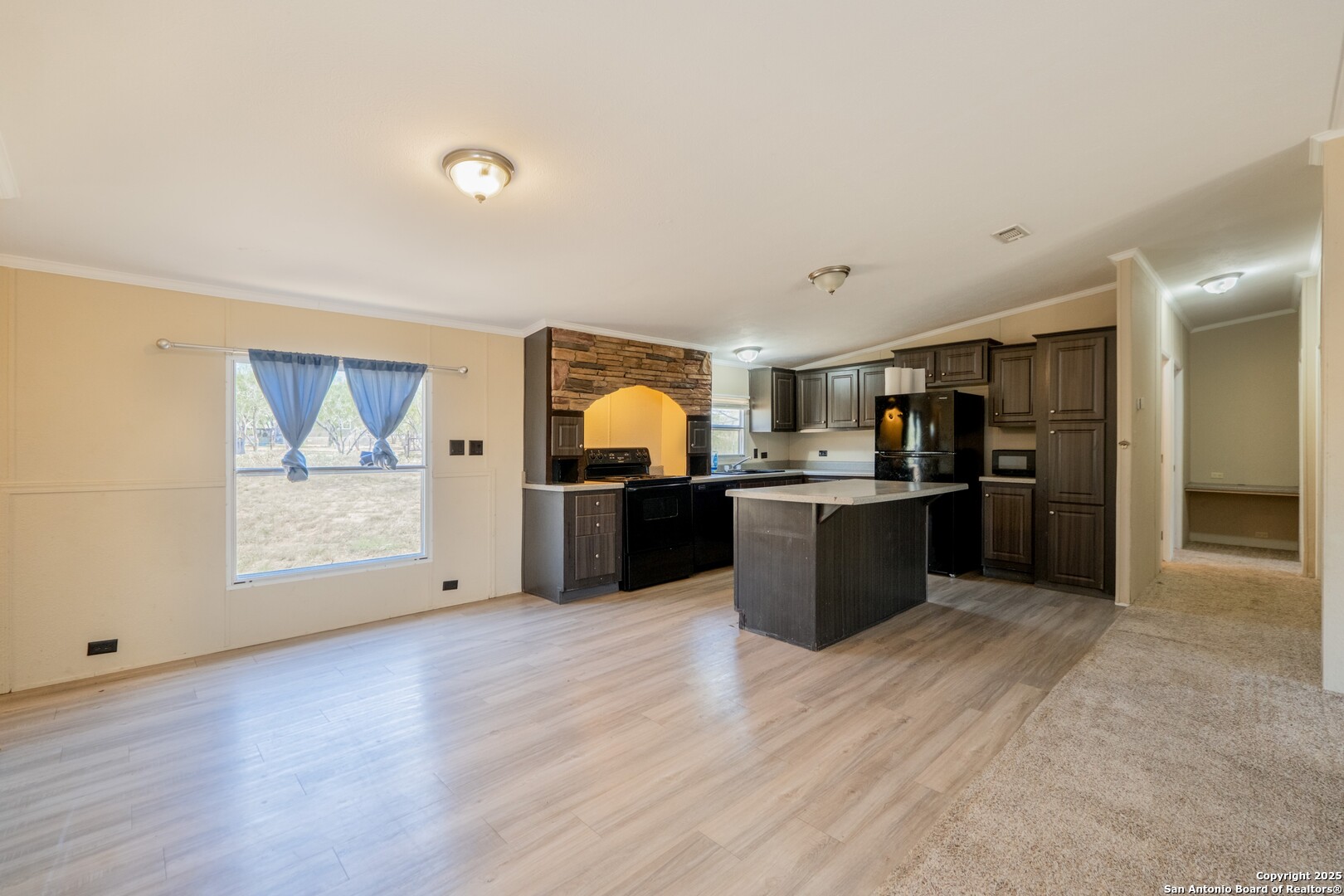 1007 County Road 773 Devine, TX 78016 - Photo 8 of 31 a large kitchen with stainless steel appliances kitchen island a large counter top and a wooden floors