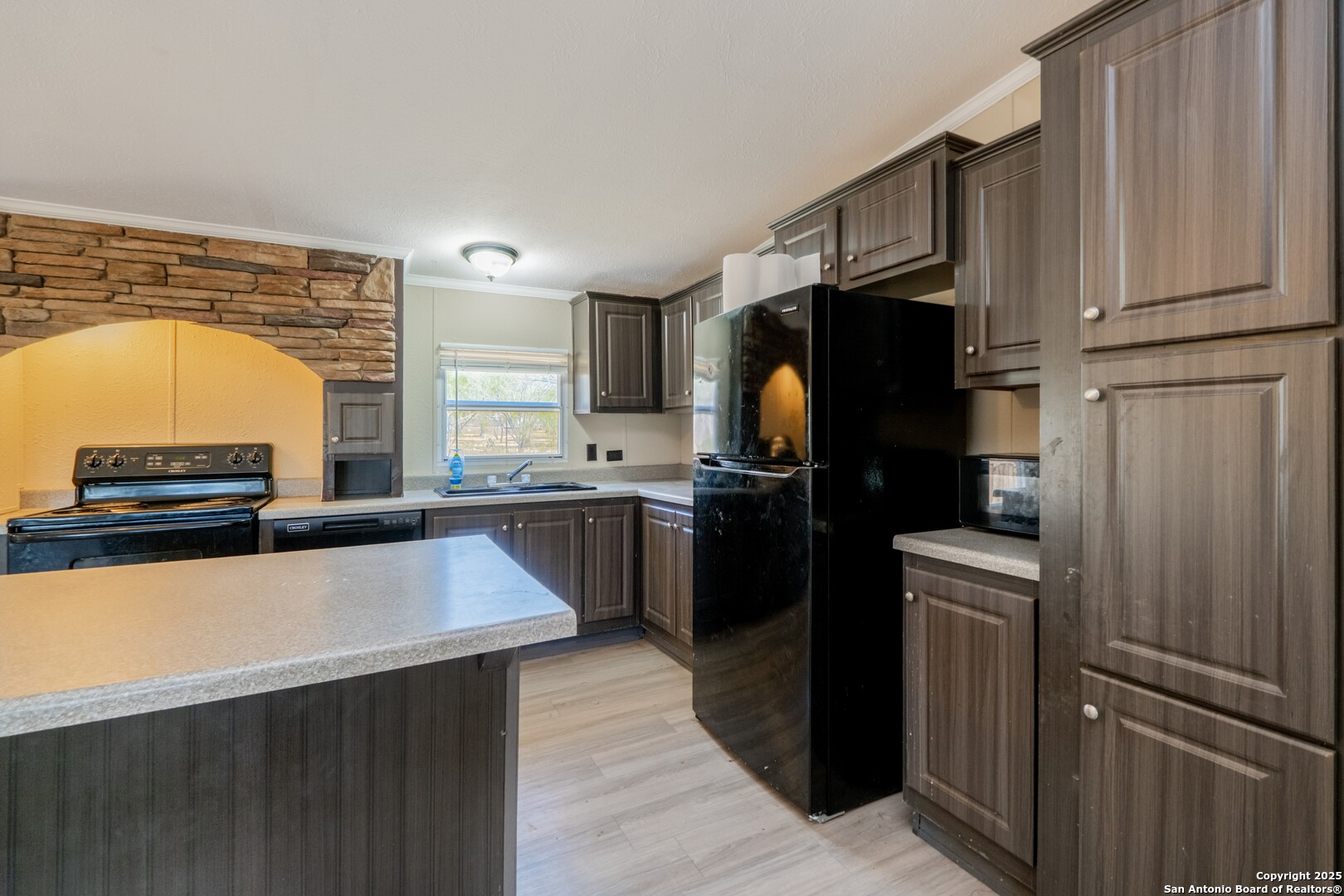 1007 County Road 773 Devine, TX 78016 - Photo 9 of 31 a kitchen with stainless steel appliances a refrigerator sink and stove