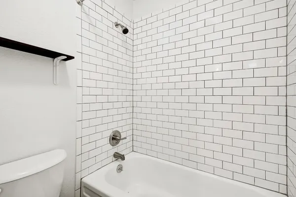 a bathroom with a white bathtub and a toilet