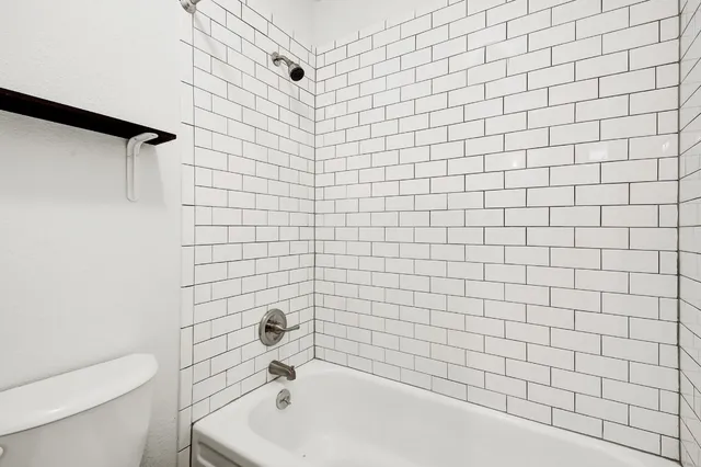 a bathroom with a white bathtub and a toilet